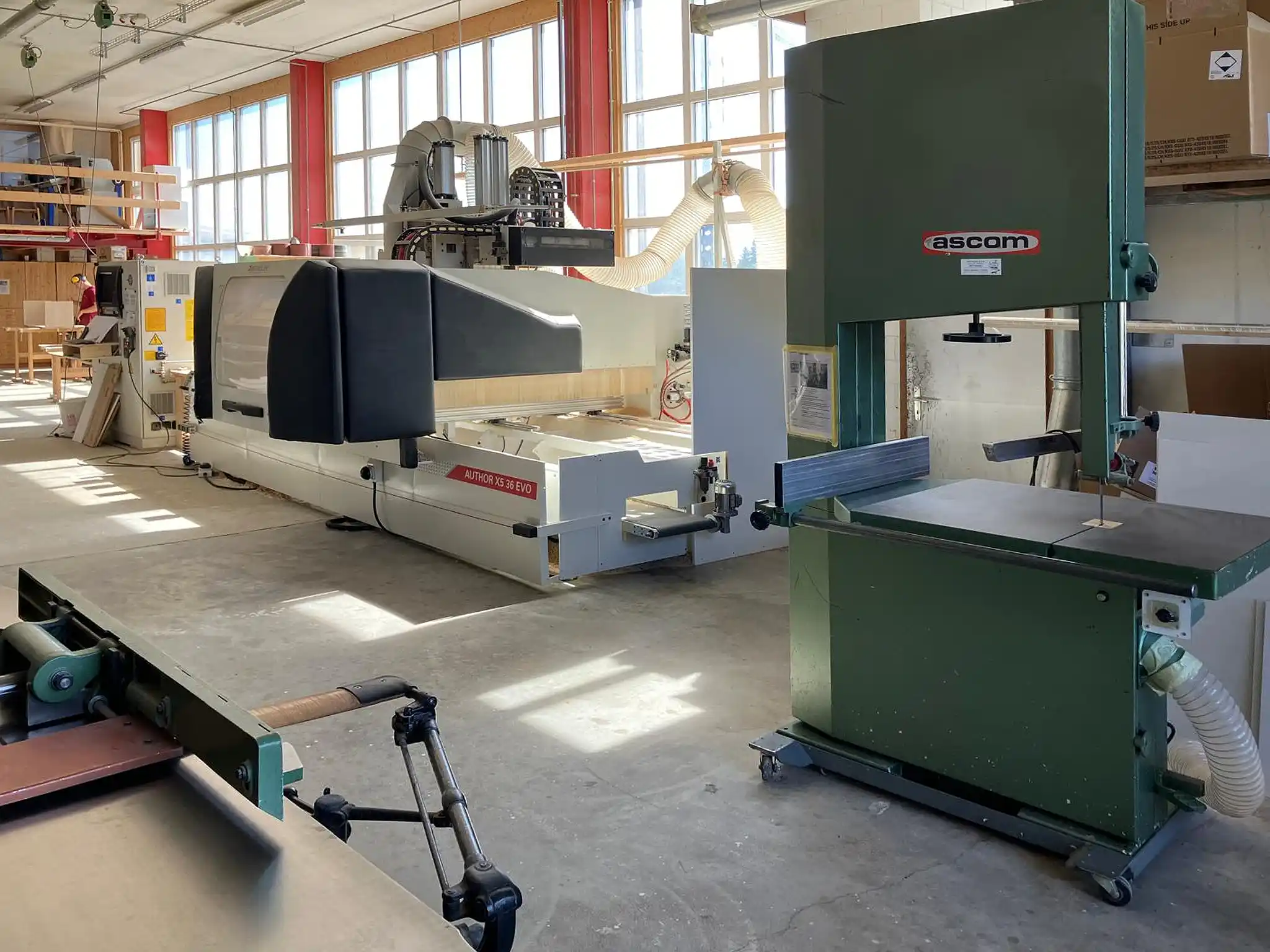 Moderne Holzwerkstatt mit CNC-Bearbeitungszentrum, Bandsäge und Absauganlage für die präzise Verarbeitung von Holz- und Plattenmaterialien. Moderne Holzwerkstatt mit CNC-Bearbeitungszentrum, Bandsäge und Absauganlage für die präzise Verarbeitung von Holz- und Plattenmaterialien.